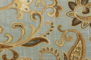 This linen rayon blend fabric features a paisley design in brown, khaki, blue, cream and hints of gold against a light blue gray background.