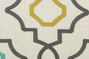 This fabric features an embossed geometric design in gray, turquoise and gold on a  natural colored background.  