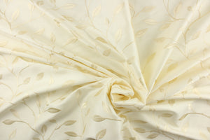 This luxurious duotone fabric features embroidered foliage on a silky cream background.