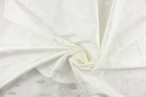  This luxurious duotone fabric features embroidered leaves on a silky white background.