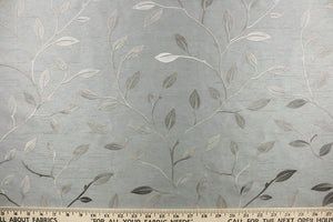 This luxurious duotone fabric features embroidered foliage on a silky slate gray background.
