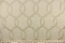 Load image into Gallery viewer,  This fabric features a modern geometric design artfully embroidered in champagne gold on a linen colored background. 

