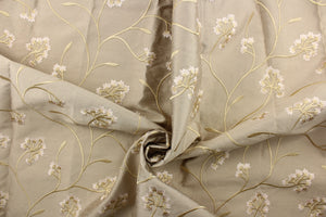 This fabric features a beautiful embossed floral design in rose gold on a dark beige background. 