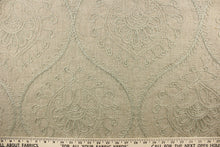 Load image into Gallery viewer, This fabric features an embossed medallion design in light green on a dark beige background.  
