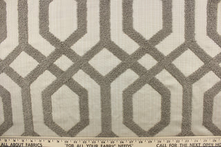 This fabric features a modern geometric design artfully embroidered with rope yarns in pewter on a natural colored background.