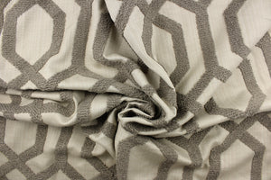 This fabric features a modern geometric design artfully embroidered with rope yarns in pewter on a natural colored background.
