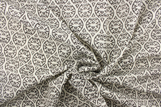  This outdoor fabric features a unique design in dark gray almost black against a white background.