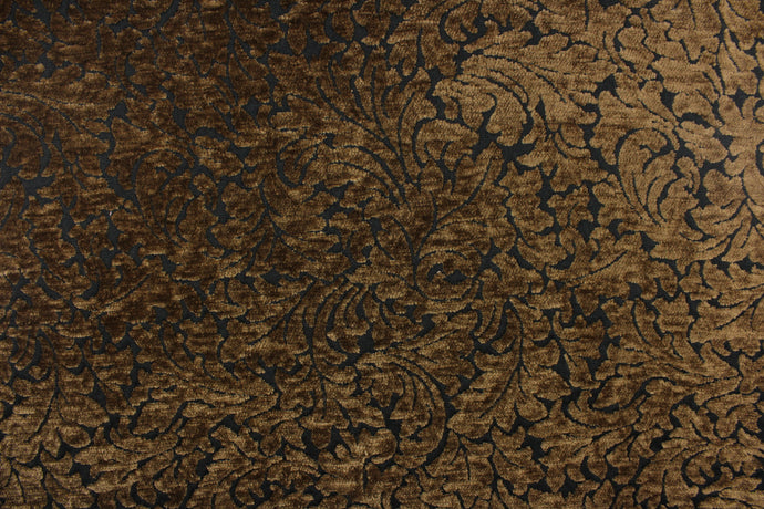 This hard wearing, textured chenille fabric features a unique leaf design in bronze on a black background.  