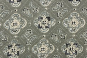 This chiffon fabric features a medallion design in blue, gray, and navy against a grayish green. This fabric is sheer.