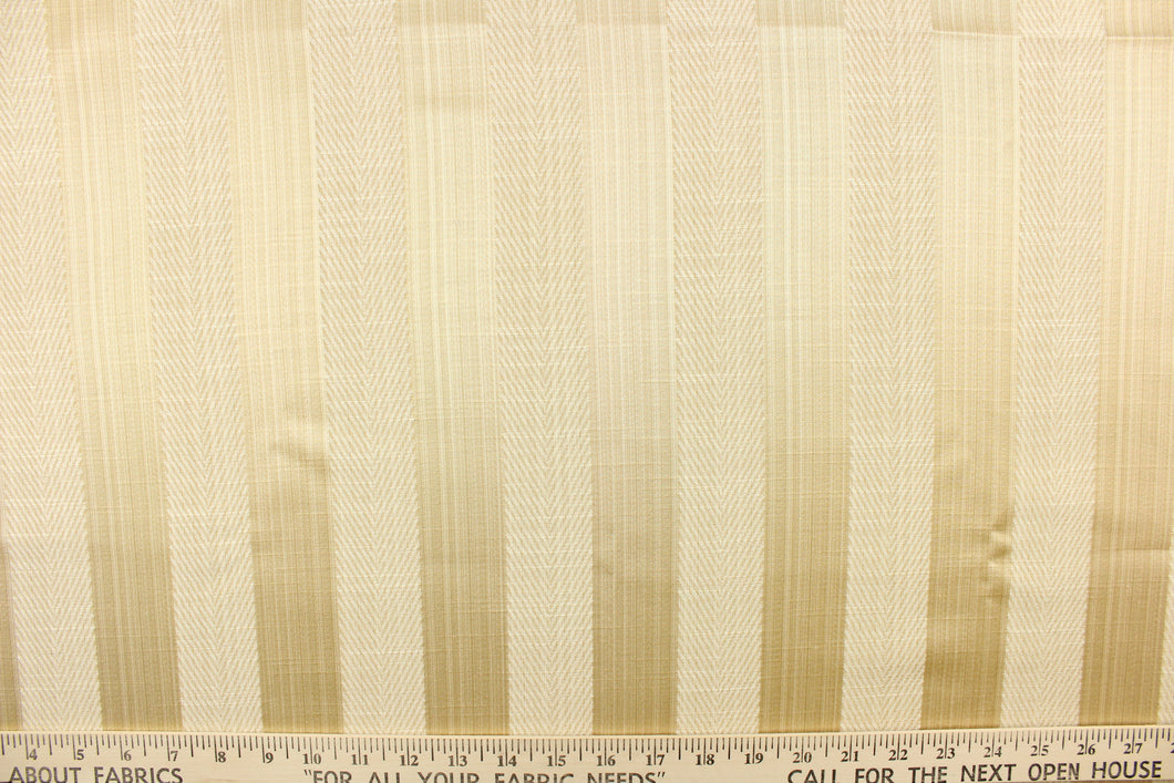 This stunning yarn dyed fabric features a  wide vertical striped pattern in cream and light gold.