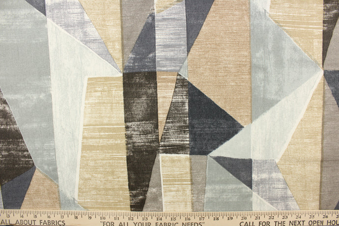 This fabric features and geometric  design of angles in gray, khaki, white and pale blue .