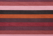 Load image into Gallery viewer, This suede lycra fabric features a horizontal stripe design in orange, black, purple, plum, mauve, and pale purple. 
