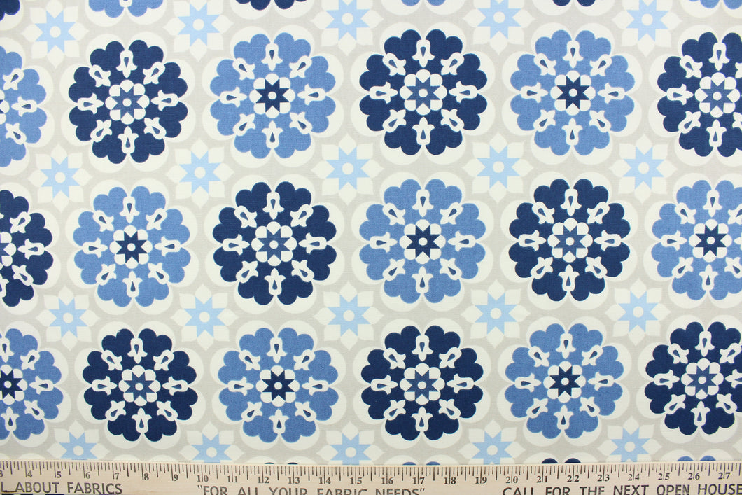  This screen printed fabric features large and small flowers in shades of blue and off white on a khaki background.