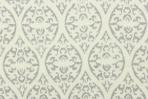 This screen printed fabric features a trellis design in gray and off white.