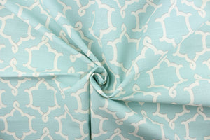  This fabric features a medallion print in ivory and gray on a robin blue background. 