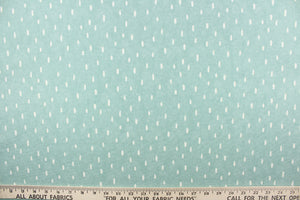 This calming fabric features cream colored raindrops on a seafoam background. 