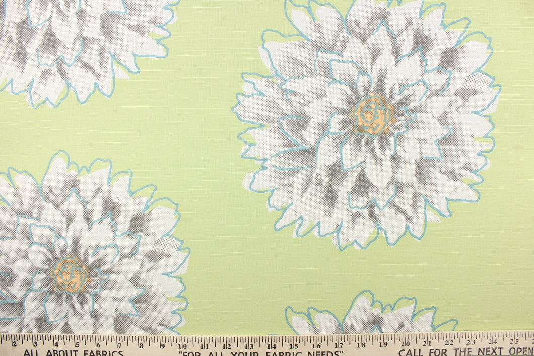 This screen printed fabric features large mum flowers in gray, orange and white with blue accents on a light green background. 