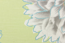 Load image into Gallery viewer, This screen printed fabric features large mum flowers in gray, orange and white with blue accents on a light green background. 
