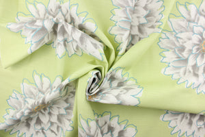 This screen printed fabric features large mum flowers in gray, orange and white with blue accents on a light green background. 