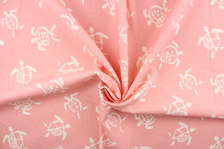 This fun fabric features cream colored turtles on a pink background.