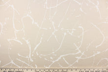 Load image into Gallery viewer, This fabric features a paint splatter design in white against a sand background. 
