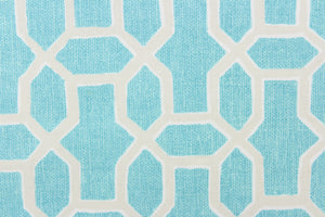 This fabric features a geometrical print in aqua and beige with white accents.  