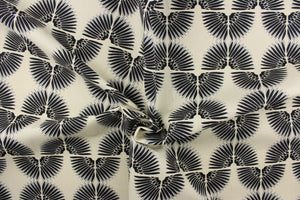 This contemporary screen printed fabric features a caterpillar in gray and black set against a beige background. 