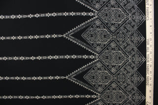 This georgette fabric features an Aztec design in pale beige against black. 