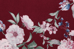 This georgette fabric features a floral design in pink, blue, and green against a burgundy background. 