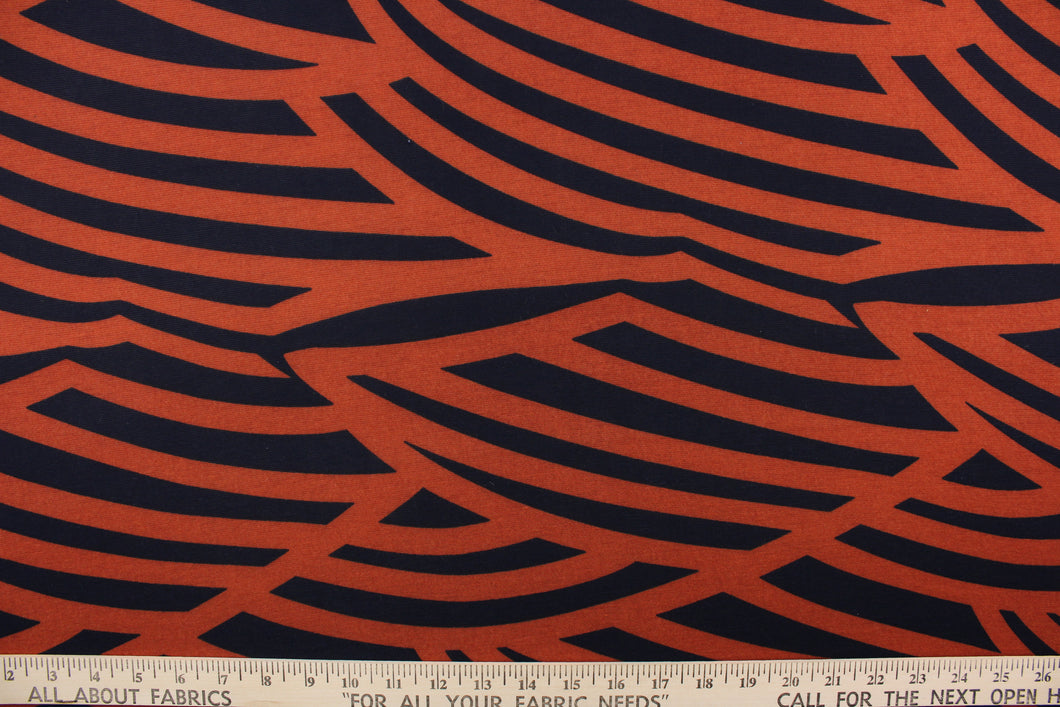 This jersey lycra fabric features a stripe design in black against a dark orange. 