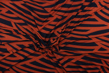 Load image into Gallery viewer, This jersey lycra fabric features a stripe design in black against a dark orange. 
