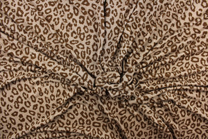 This jersey fabric features a leopard design in brown against a taupe. This is a interlock knit acetate jersey.