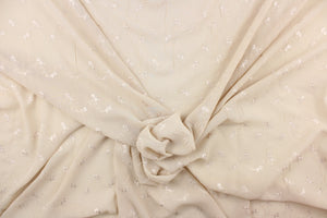 This chiffon fabric features a floral eyelet design in cream against a pale khaki.