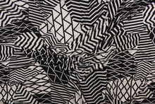 Load image into Gallery viewer, This 4 way stretch lycra fabric features an abstract design in black, and pale beige. 
