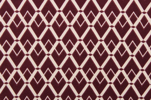 This 2way stretch lycra fabric features a geometric  design of diamonds in burgundy  and off white.