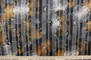 This chiffon fabric features a snakeskin design in tan, black, gray, and gold.