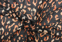 Load image into Gallery viewer, This chiffon fabric features a leopard design in a faded out orange against black. 
