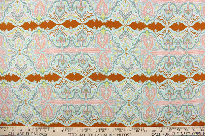 This chiffon fabric features a demask design in pale blue, seafoam green, pink, white, and yellow against a brown orange. 