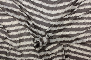 This chiffon fabric features a stripe design in  a taupe and gray. 