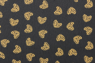  This chiffon fabric features a heart design with a leopard design in tan and black against a black  background.