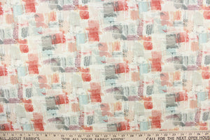 This fabric features an abstract design in coral, pink, gray, pale blue, pale nude, purple, and dull white.