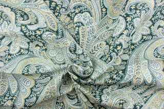 This fabric features a paisley design in green tones, white, olive, teal, golden tan, and blue green.