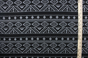 This jersey fabric features a Mayan/Aztec  design in  black and gray.