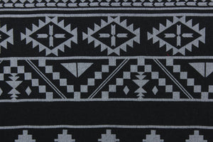 This jersey fabric features a Mayan/Aztec  design in  black and gray.