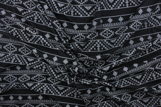 This jersey fabric features a Mayan/Aztec  design in  black and gray.