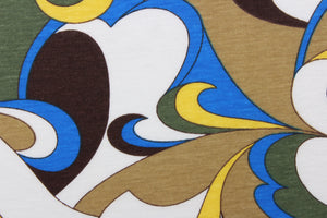 This jersey fabric features an abstract design in blue, yellow. olive green, brown, tan and white. 