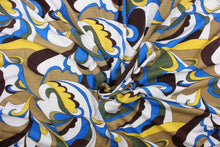 Load image into Gallery viewer, This jersey fabric features an abstract design in blue, yellow. olive green, brown, tan and white. 
