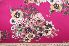 Load image into Gallery viewer, This jersey fabric features a floral design in pink, mauve, purple, green, golden tan, deep pink and white. 
