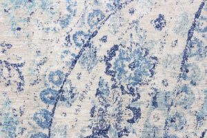 This fabric features a paisley design in varying shades of blue with some gray undertones against a off white.