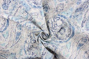 This fabric features a paisley design in varying shades of blue with some gray undertones against a off white.